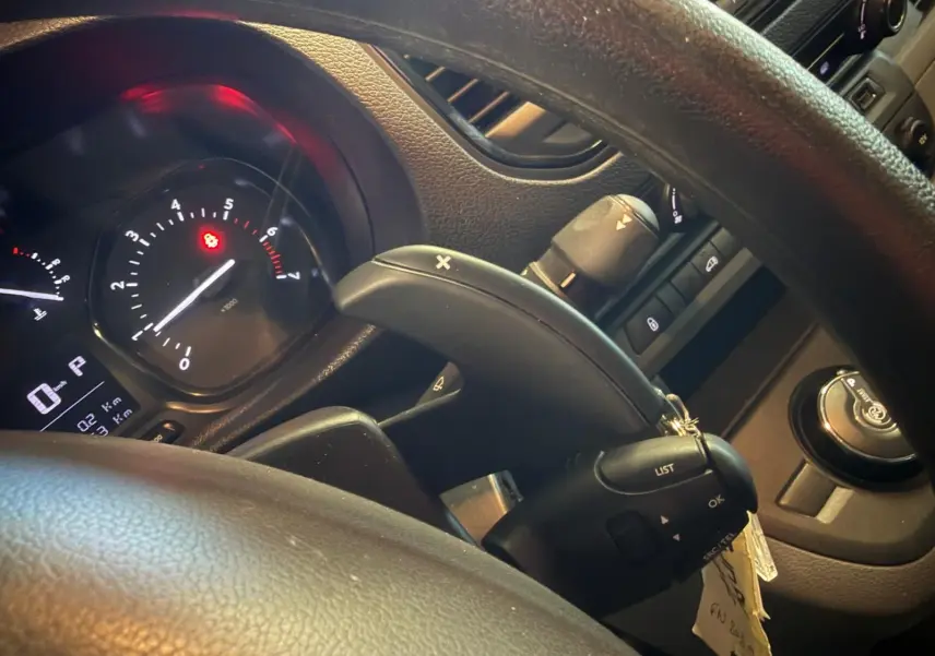 Vue rapprochée du tableau de bord et du volant du Citroën Jumpy gris, montrant les commandes au volant et l'indicateur de régime.