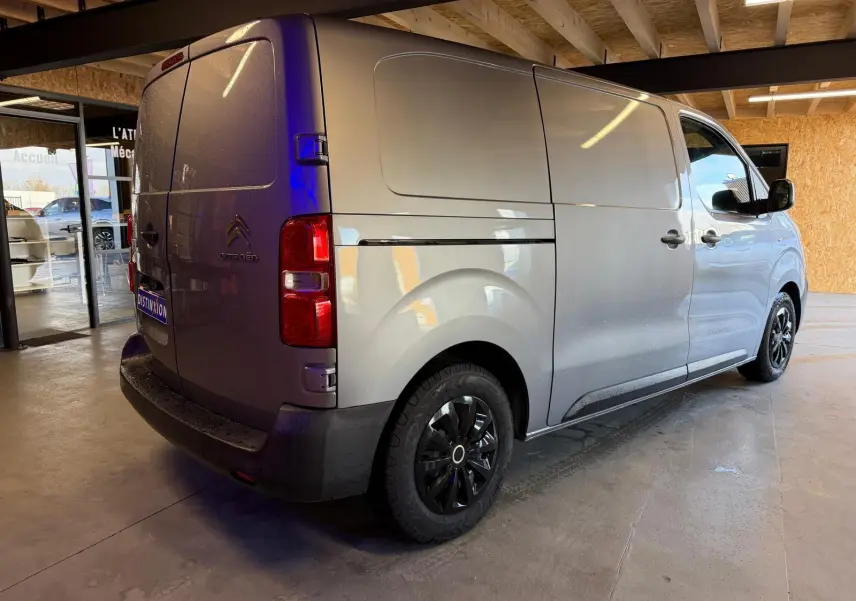 Vue 3/4 arrière droite du Citroën Jumpy gris métallisé 2022 avec portes battantes et jantes noires.