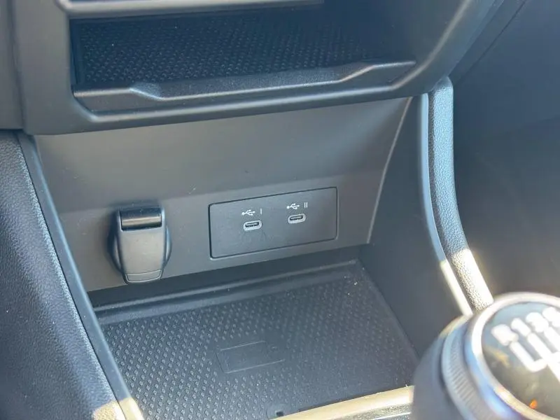 Gros plan sur la console centrale du Renault Captur 2025, montrant les ports USB-C et la prise 12V, intérieur noir.