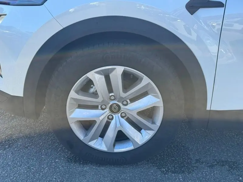 Gros plan sur la roue avant droite d’un Renault Captur blanc nacré 2025 avec jante alliage et pneu Continental.