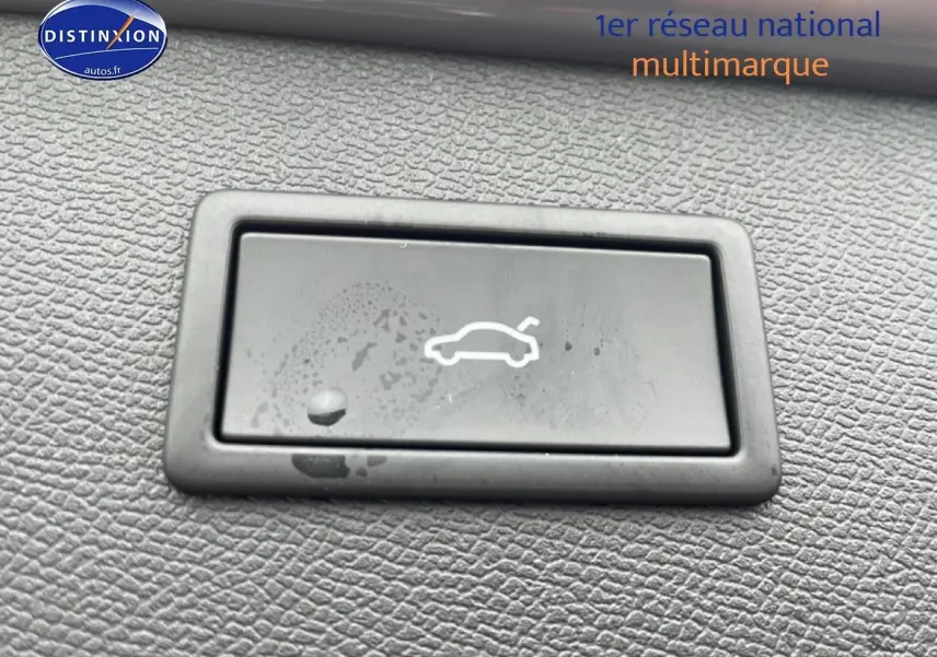 Bouton d'ouverture du coffre en plastique noir sur tableau de bord texturé d'un CUPRA Formentor gris graphene.