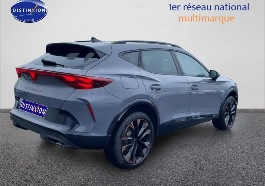 Vue 3/4 arrière droite d’un CUPRA Formentor gris graphene avec jantes 19 pouces et feux arrière LED allumés.