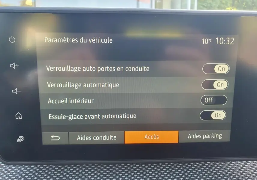 Écran tactile intérieur du tableau de bord du Dacia Sandero 2024 affichant les paramètres de verrouillage et essuie-glace automatique.
