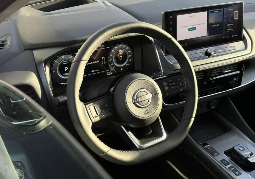 Vue intérieure du volant beige et du tableau de bord numérique du Nissan Qashqai III e-Power avec écran tactile 12,3 pouces.
