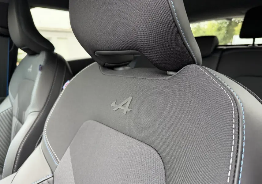 Gros plan sur les sièges avant noirs du Renault Captur Esprit Alpine, avec logo Alpine embossé et surpiqûres bleues.