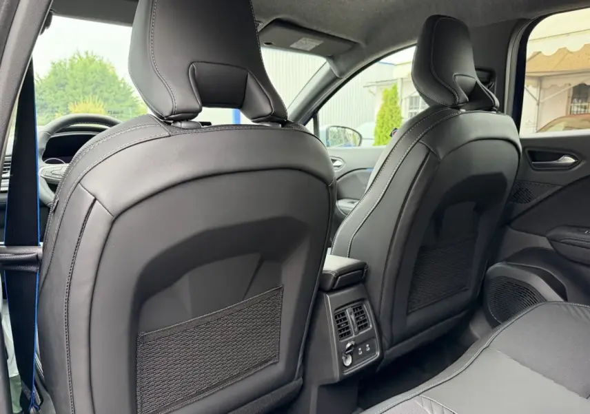 Vue arrière intérieure des sièges avant en cuir noir du Renault Captur bleu esprit Alpine full hybrid 2026, avec console centrale et aérateurs.