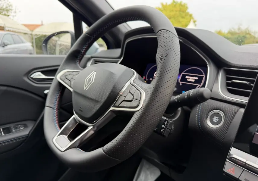 Vue intérieure rapprochée du volant cuir perforé et du tableau de bord du Renault Captur esprit Alpine 2026.