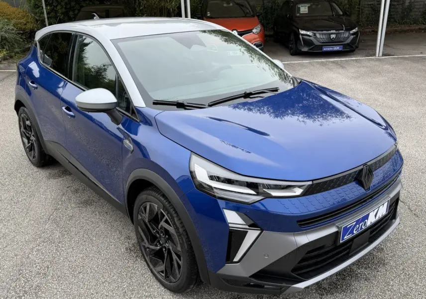 Vue 3/4 avant gauche du Renault Captur Esprit Alpine bleu avec toit blanc et jantes noires distinctives.