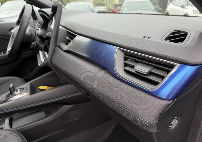 Vue intérieure côté passager du tableau de bord bleu et noir du Renault Captur Esprit Alpine hybride 2026.