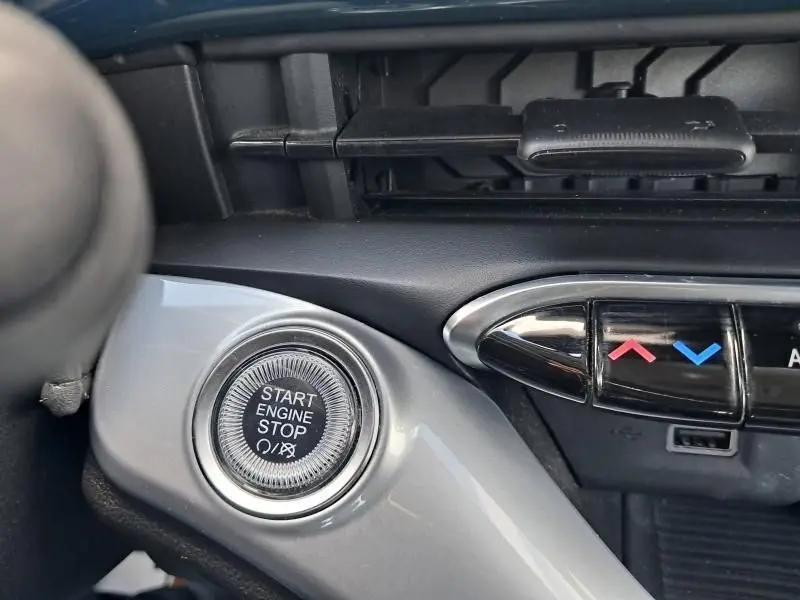 Bouton start/stop moteur en gros plan sur le tableau de bord de la FIAT 500C électrique vert foncé métal 2021.