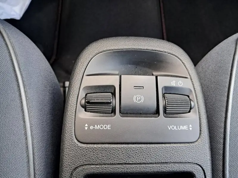 Gros plan sur les commandes centrales de la Fiat 500C électrique 2021, avec réglage e-mode et volume entre les sièges.