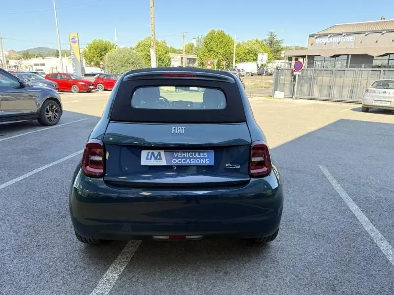 Vue arrière d'une FIAT 500C Icone 118 cv électrique vert foncé métallisé avec toit noir en stationnement.