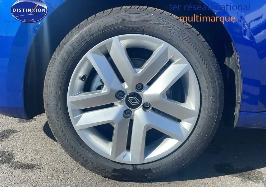 Gros plan sur la roue avant gauche avec enjoliveur argenté d'une Renault Clio V bleu iron.