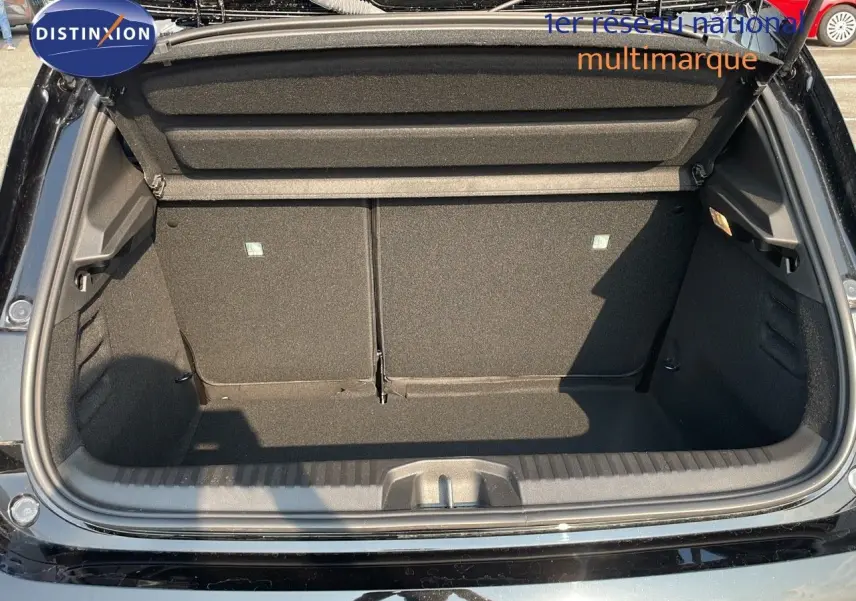 Coffre ouvert vu de l'arrière d'une Renault Clio 1.5 DCI noire étoile métal, montrant l'espace de chargement vide.