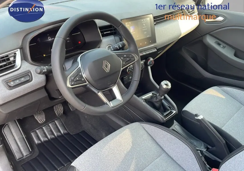 Intérieur de la Renault Clio 1.5 DCI 2025, vue du poste de conduite côté gauche avec volant, tableau de bord digital et sièges gris.
