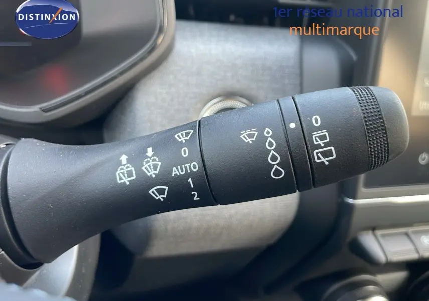 Gros plan sur la commande des essuie-glaces d'une Renault Clio 1.5 DCI 100ch Evolution 2025, intérieur gris.