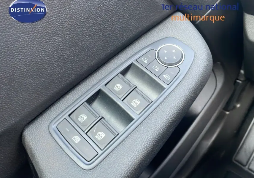 Gros plan sur les commandes des vitres électriques côté gauche de la Renault Clio noire étoile métal 2025.