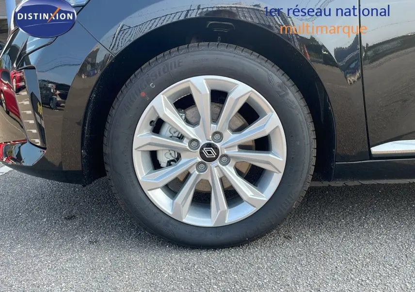 Gros plan sur la roue avant gauche d'une Renault Clio noire étoile métal avec jante alliage 16 pouces.