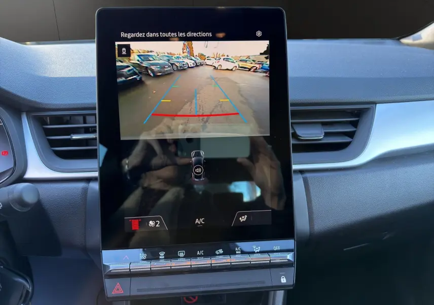 Écran central du Renault Captur 2024 gris cassiopée avec caméra de recul affichant l'image arrière en stationnement.