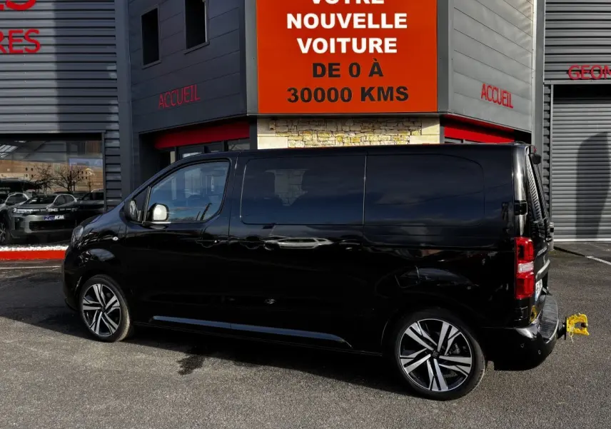 FIAT Scudo Fourgon noir vu de profil côté gauche, avec jantes alliage et attelage arrière visible.