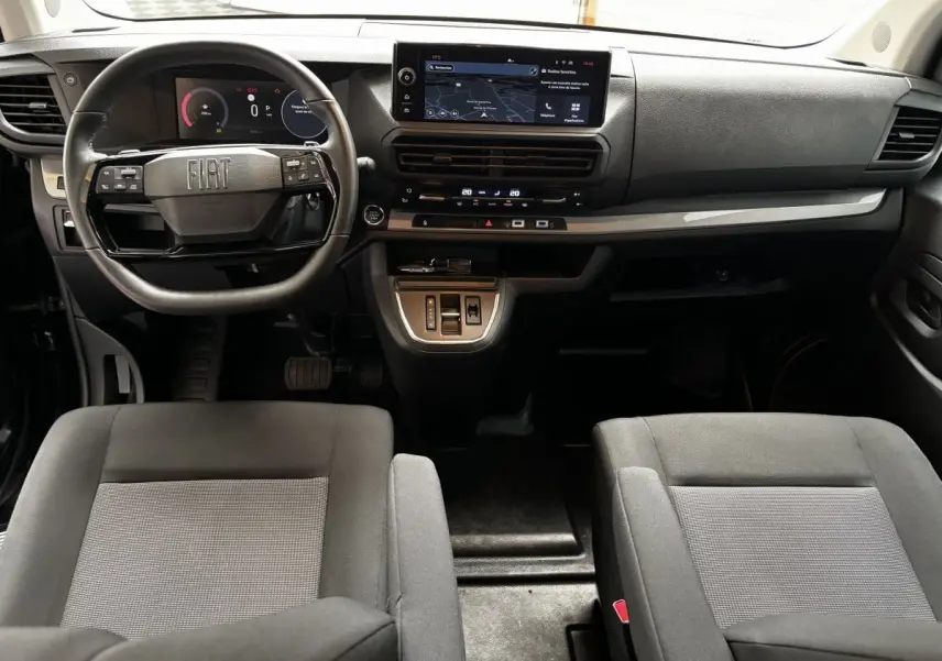 Vue intérieure avant du Fiat Scudo Fourgon 2025 noir, tableau de bord moderne avec écran tactile et volant multifonction.