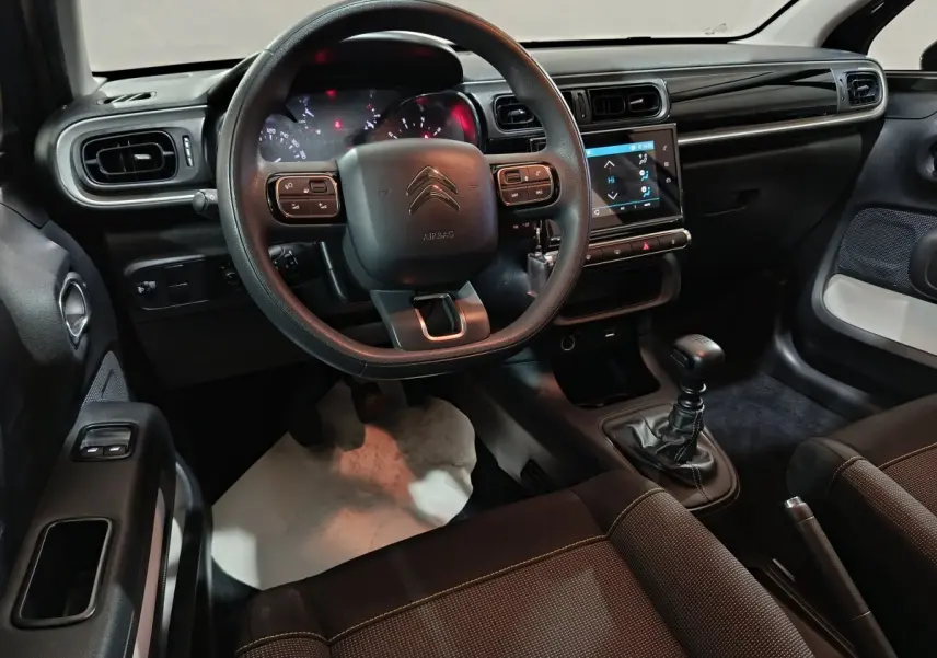 Intérieur noir de la Citroën C3 2024, vue de face sur le volant multifonctions et la console tactile centrale.