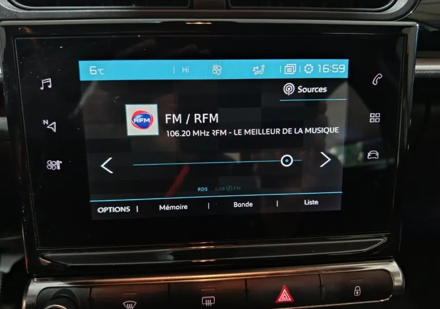 Écran tactile central de la Citroën C3 gris foncé 2024 affichant la radio FM avec commandes tactiles autour.