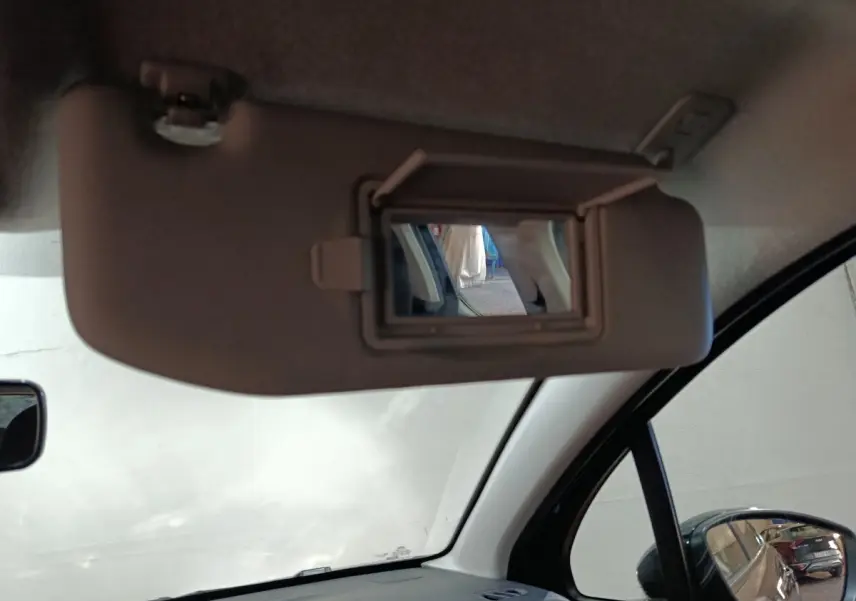 Vue intérieure du pare-soleil côté conducteur avec miroir de courtoisie ouvert sur Citroën C3 gris foncé 2024.