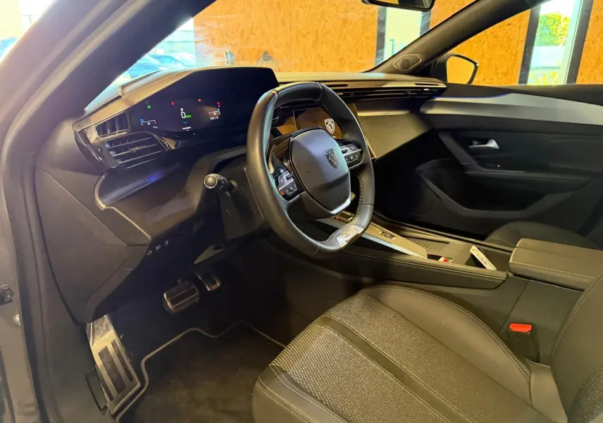 Intérieur avant droit du Peugeot 408 gris, volant compact, tableau de bord numérique et sellerie tri matières.