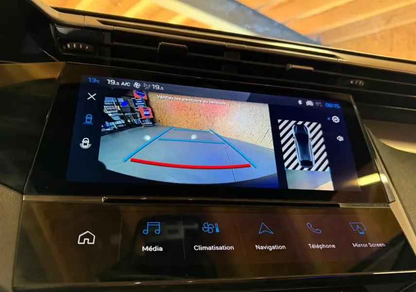 Écran tactile central de la Peugeot 408 gris, affichant la caméra de recul avec aides au stationnement.