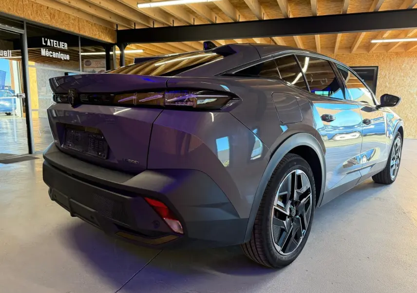 Vue 3/4 arrière droite de la Peugeot 408 gris métallisé avec jantes alliage 19'' diamantées et feux arrière LED griffés.