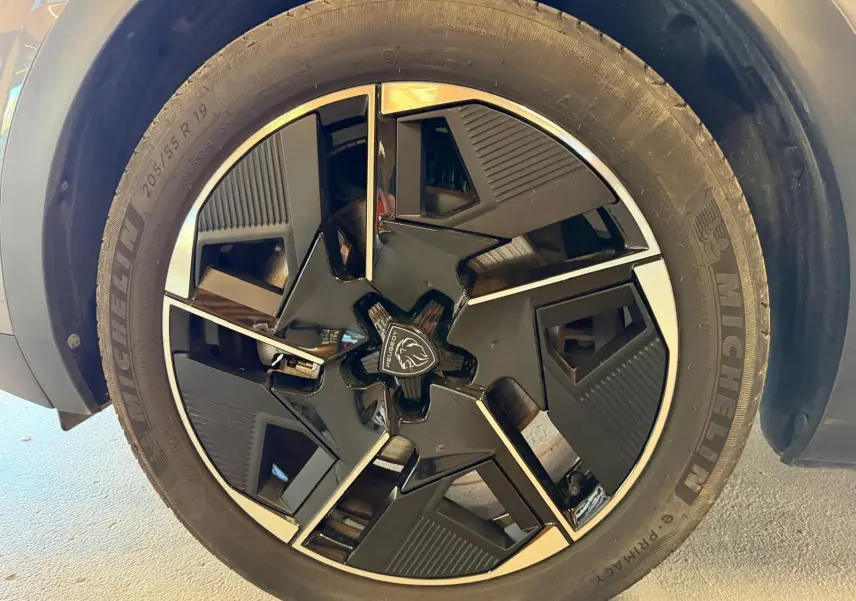 Gros plan sur la jante alliage 19'' diamantée graphite de la Peugeot 408 gris Selenium, avec logo Lion central.