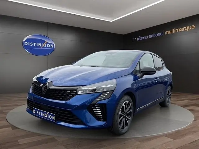 Renault Clio Techno E-Tech hybride bleu en 3/4 avant droit, avec feux LED et jantes alliage noires.