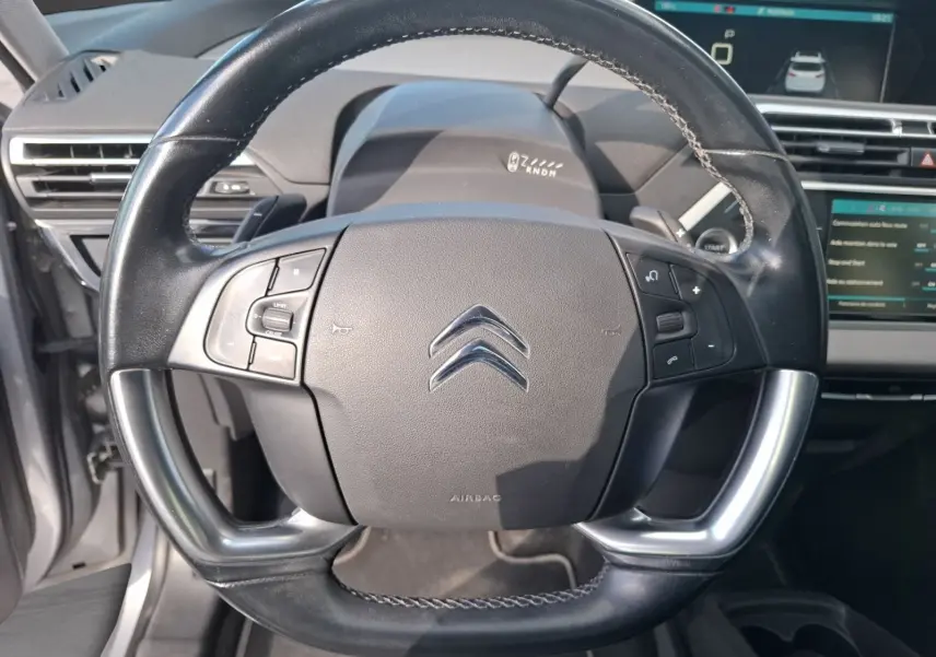 Vue rapprochée du volant cuir noir de la Citroën C4 Picasso 2018 avec commandes intégrées et tableau de bord visible.