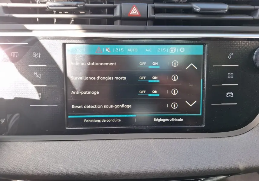 Vue rapprochée de l’écran tactile central du tableau de bord du Citroën C4 Picasso gris clair, affichant les réglages d’aide à la conduite.