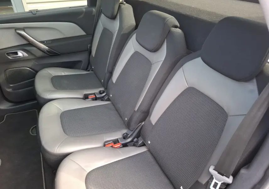 Vue latérale droite des sièges arrière cuir et tissu gris clair du Citroën C4 Picasso 2018 avec appuie-têtes intégrés.