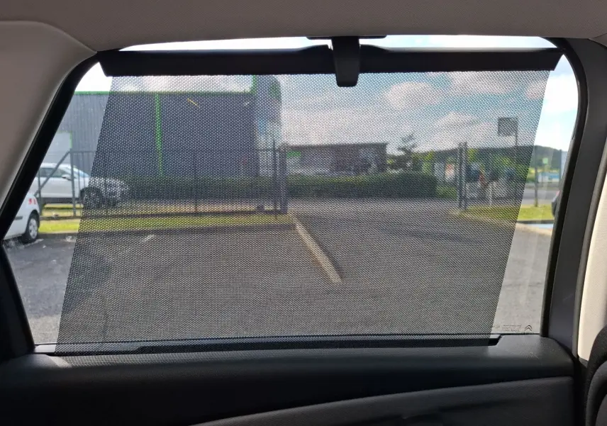 Vue intérieure sur le rideau pare-soleil de la vitre arrière côté droit du Citroën C4 Picasso gris clair 2018.