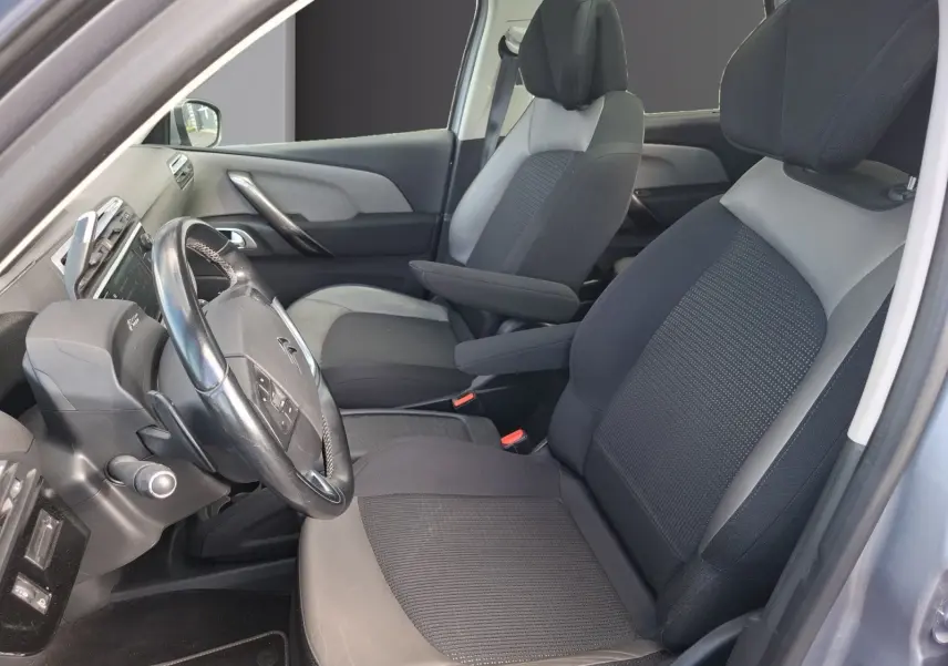 Vue intérieure côté conducteur de la Citroën C4 Picasso 2018, sièges cuir et tissu gris, volant multifonctions visible.