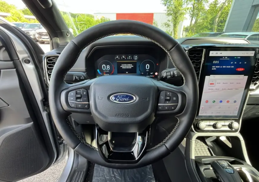 Vue intérieure centrée sur le volant cuir noir et l'écran tactile vertical du Ford Ranger gris iconic 2026.