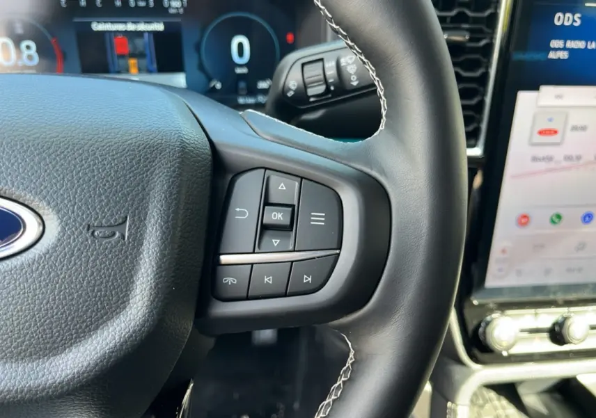 Gros plan sur le volant cuir multifonctions du Ford Ranger 2026 avec commandes intégrées et tableau de bord numérique.