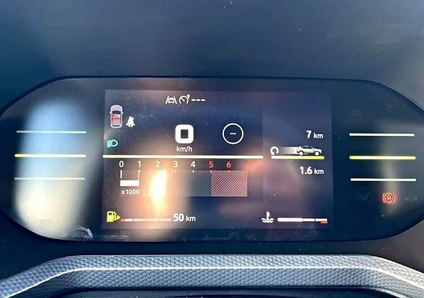 Tableau de bord numérique du Dacia Duster 2026 affichant la vitesse, la jauge de carburant et les alertes, vue frontale rapprochée.