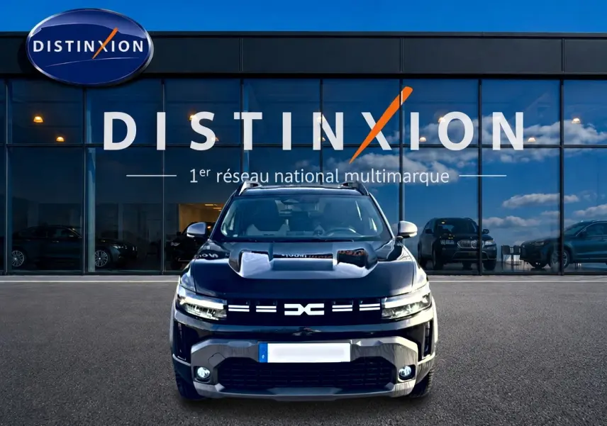 Vue avant d'un Dacia Duster 1.2 mild hybrid noir avec calandre distinctive et phares LED allumés.