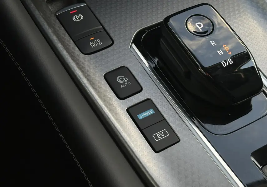 Gros plan sur la console centrale noire et grise du Nissan Qashqai 2026 avec sélecteur de boîte auto et boutons e-Pedal et EV.