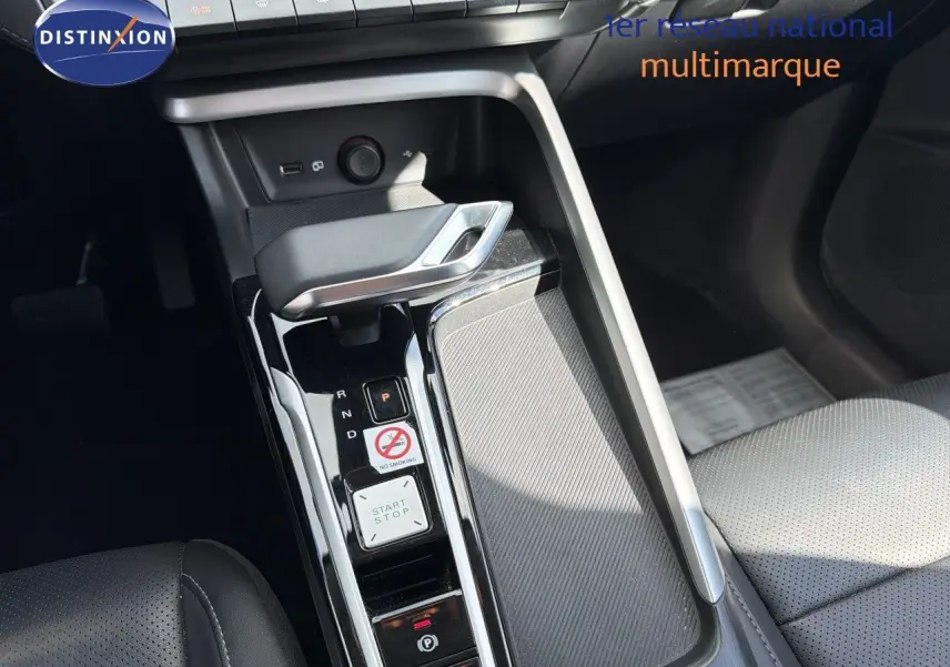 Gros plan sur la console centrale avec levier de boîte auto et bouton start/stop dans l’habitacle noir du MG ZS 1.5L Hybrid+ 2025.