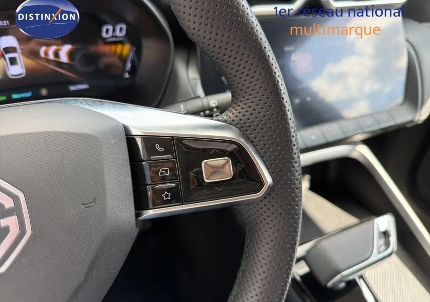Gros plan sur le volant perforé côté gauche du MG ZS 1.5L Hybrid+ 2025 avec commandes intégrées et tableau de bord numérique.