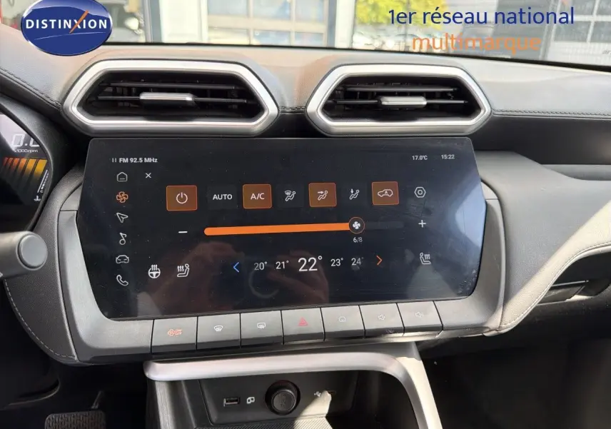 Vue rapprochée du tableau de bord du MG ZS 2025, écran tactile central avec commandes climatisation affichées.
