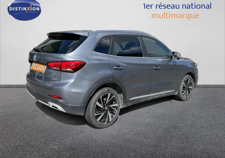 Vue 3/4 arrière droite d’un MG ZS 1.5L Hybrid+ 197ch Luxury gris métallisé Hampstead avec jantes alliage bicolores.