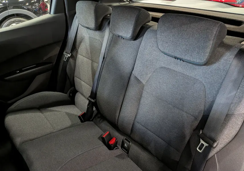 Vue rapprochée des sièges arrière en tissu gris de la Renault Clio VI 1.2 TCe 115 CH Evolution, avec ceintures de sécurité visibles.