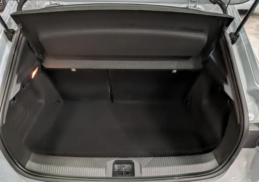 Coffre ouvert vu de face d'une Renault Clio VI gris Rafale, montrant l'espace de rangement intérieur vide.