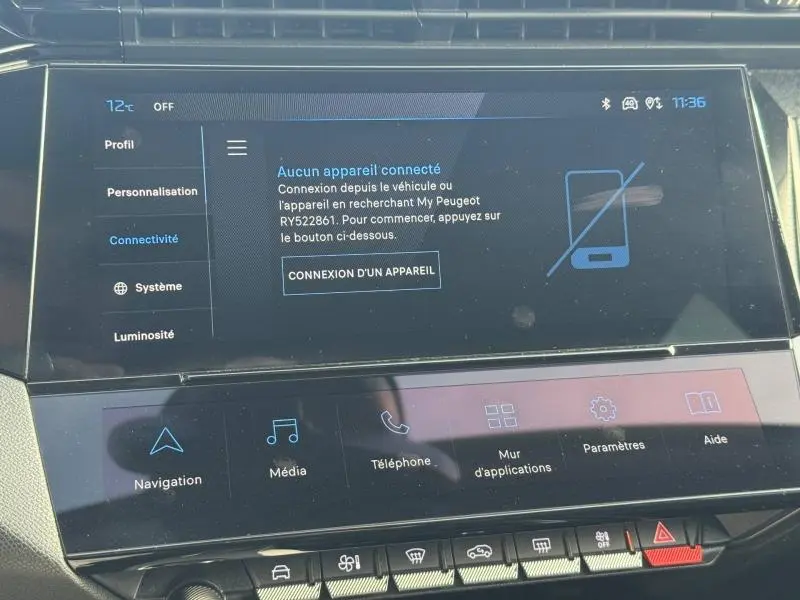 Écran tactile central de la Peugeot 308 2024 en gros plan, affichant le menu connectivité sur fond noir.